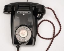 A black bakelite model 321 'ramshead' wall telephone:, with silvered dialer.