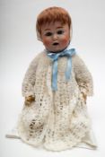 A Schutzmeister & Quendt baby doll: with glass eyes and open mouth revealing two teeth,