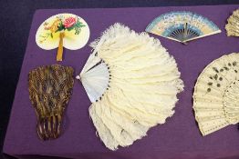 A late 19th century ivory and embroidered fan together with two white ostrich feather fans,
