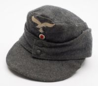 A Third Reich period Luftwaffe M43 visor cap:, cloth eagle and swastika over a cloth cockade,