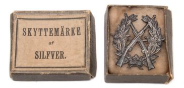 A late 19th/early 20th century whitemetal marksmanship badge:,