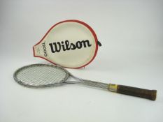 A Wilson T2000 steel frame tennis racket:, with brown leather grip and red and white racket cover,