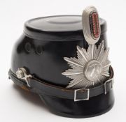 A German Police shako helmet:, black bodied with aluminium star and cockade,