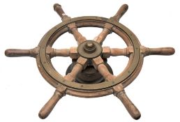 A teak and brass helm:, on a brass boss,