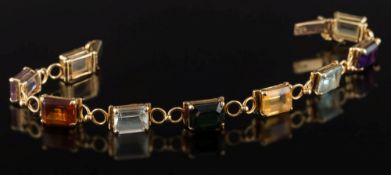 A multi-coloured gem-set bracelet: with nine rectangular gemstones in four-claw settings,