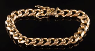A heavy curb-link bracelet: stamped '18K', approximately 20cm total length, 63gms gross weight.