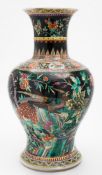 A Chinese famille noire baluster vase: painted with peacocks, insects,
