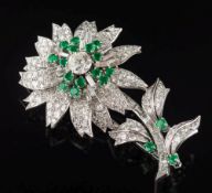 An emerald and diamond mounted flower brooch: the central stamen represented by a single round old