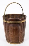 An 18th Century mahogany and brass bound ribbed peat bucket:, with brass swing carrying handle,