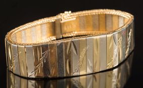 A two-colour bracelet: of bright-cut and polished tapering links, the clasp stamped '750',