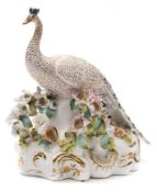 A Stevenson and Hancock Derby porcelain figure of a peacock: the bird perched on a flower encrusted