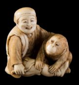 A Japanese carved ivory okimono, signed Tomokazu: of a monkey trainer,
