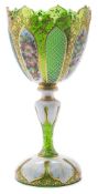 A Bohemian green and white overlay glass pedestal vase: of foliate form on a domed foot,