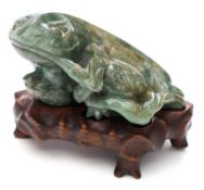 A Chinese jadeite toad and pomegranate carving: the toad with a stem of the plant in its mouth,