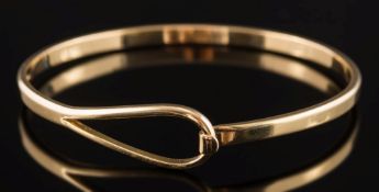 An 18ct gold torc-style bangle: with hook and loop terminal, 19gms gross weight.