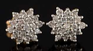 A pair of 18ct gold and diamond mounted circular cluster earrings: with clusters of small circular