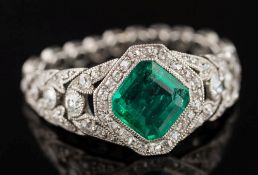 An emerald and diamond ring: the step-cut emerald approximately 7.5mm corner to corner x 2.