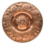 A large Arts and Crafts copper circular plaque: embossed with a central Tudor rose,