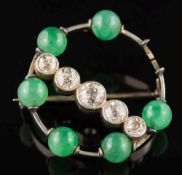 A jade and diamond circular brooch: set with a surround of jade beads each approximately 6mm
