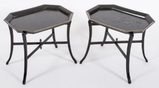 A pair of black lacquer and papier mache octagonal trays on folding X-frame stands:,