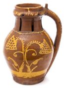 A slipware pottery puzzle jug: with pieced neck, four spouts and hollow handle,