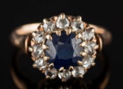 A sapphire and diamond mounted circular cluster ring: with central cushion-shaped sapphire 5.