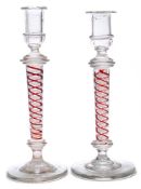 A close pair of glass two colour opaque twist glass candlesticks: each with clear nozzle and drip