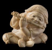 A Japanese carved ivory okimono, signed Kogyoku: of a seated man playing the flute, Meiji period, 3.