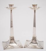 A pair of George V Arts and Crafts influence candlesticks, maker George Edwards & David Edwards,