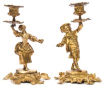 A pair of French gilt bronze figural candlesticks: modelled as a youth and female companion holding