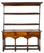 An 18th Century oak dresser:, the open shelved superstructure with a moulded cornice,