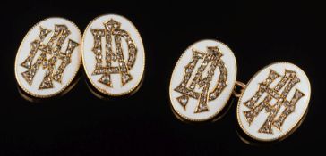 A pair of white enamelled gold and rose diamond oval cuff-links: each inset with monogram,