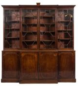 A George III mahogany breakfront library bookcase:, the upper part with a moulded cornice,
