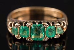 An 18ct gold and emerald five-stone ring: with graduated rectangular emeralds,
