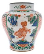 A Chinese porcelain jar enamelled in the Wucai palette: with three panels containing lion dogs and