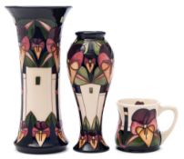 Two matching Moorcroft pottery vases and a mug: the vases of waisted cylinder and baluster form,