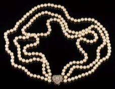 A cultured pearl three-string necklace: with a diamond mounted heart-shaped clasp, 14.