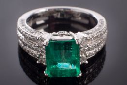 A platinum, emerald and diamond ring: the octagonal-cut emerald approximately 8.7mm long x 7.