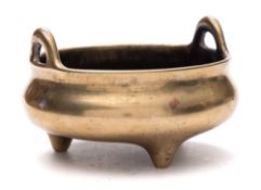 A small Chinese bronze tripod censer: of compressed circular form with loop handles,