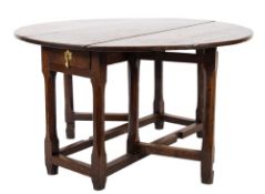 An 18th Century oak oval gateleg table:, with a hinged top, the frieze fitted with a drawer,