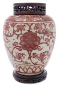 A Chinese porcelain jar: of oviform painted in copper red with phoenix and peony between lappet and