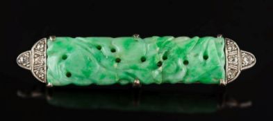 A jade and diamond bar brooch: set with a pierced carved jade panel between millegrain set diamond