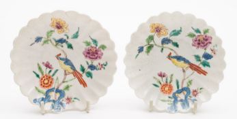 A pair of Chelsea fluted saucers: painted in bright famille rose colours with a long-tailed bird
