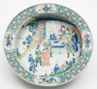 A large Chinese famille verte bowl: finely painted with warriors and other figures in audience