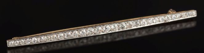 An early 20th century platinum-faced gold and diamond mounted line bar brooch: of tapering form,