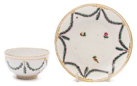 A Chelsea-Derby tea bowl and saucer: painted predominantly in green and pink enamels with a husk