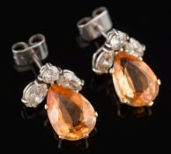 A pair of topaz and diamond drop earrings:, each with a pear-shaped topaz,