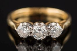 An 18ct gold and graduated diamond three stone ring: with circular,