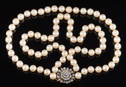 A cultured pearl two-string necklace: with diamond mounted flower head cluster clasp.