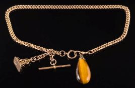 A 9ct gold curb-link chain with attached pear shaped tiger's-eye pendant,